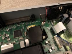 Zbliżenie wnętrza odtwarzacza Blu-ray z widocznymi elementami elektroniki, w tym chip BCM7633 i radiator.