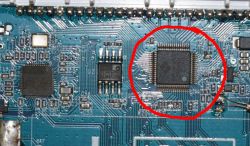 Photo of a circuit board with a large square integrated circuit marked in red.