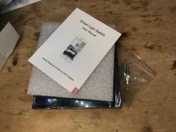 Accessories and Manual for Black Dual Light Switch Instruction manual and accessories for a black dual light switch.