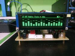 OLED display showing audio spectrum analyzer with radio playback
