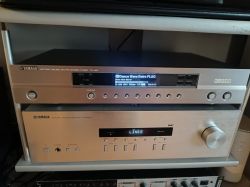 Yamaha TX-497 tuner above a Yamaha R‑S300 receiver on a shelf; displays show “Dance Wave Retro FLAC” and “LINE2”.