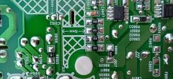 Zbliżenie na tylnią część płytki drukowanej PCB z widocznymi gniazdami do montażu rezystora, kondensatora i tranzystora.
