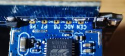 Close-up of a circuit board with visible pins labeled CEN and ADC on a blue background.