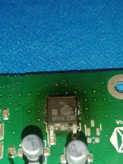 Zbliżenie na zieloną płytkę drukowaną z kilkoma elementami elektronicznymi, w tym układem scalonym oznaczonym 9H1G 33C.