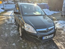 Black Opel parked in a wintery yard, front three-quarter view.
