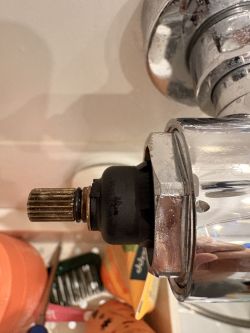 Zbliżenie na trzpień i czarną blokadę w chromowanym termostacie prysznicowym