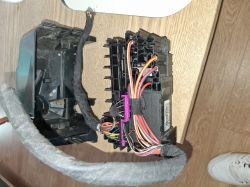 Electronic module with a cable harness on a wooden desk.