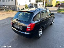 Black Škoda Fabia Kombi parked outside a building.