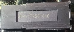 Microchip with Serial Number 3DV71T250164G Close-up of a black rectangular chip with the serial number 3DV71T250164G.