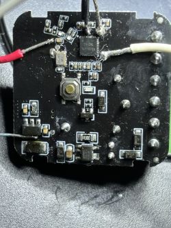 Close-up of a PCB with SMD components, soldered wires, and a small push button