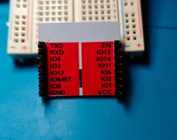 Electronic module with various pins placed on a breadboard.
