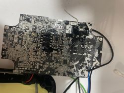 Zbliżenie na uszkodzoną płytkę drukowaną z widocznymi komponentami elektronicznymi i zaciekami.