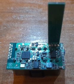Electronic module with various integrated circuits on a wooden surface.