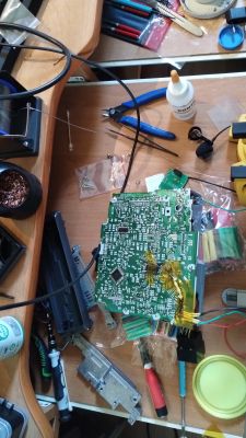 Płyta PCB z modyfikacją i przewodami na stole roboczym.