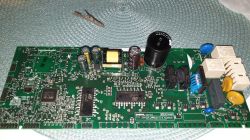Printed circuit board with various electronic components on a green background.