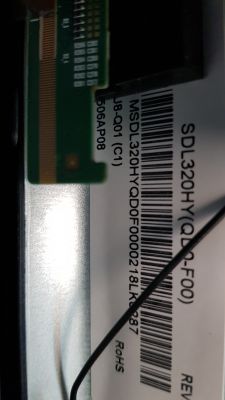 Zdjęcie etykiety z kodem kreskowym i numerem seryjnym na urządzeniu elektronicznym.