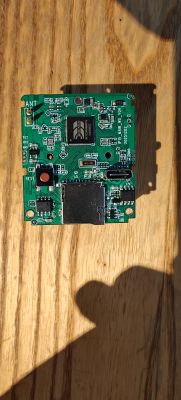 Green PCB with microSD slot, micro-USB port and a button on a wooden surface
