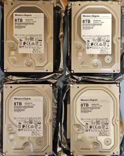 Cztery dyski twarde Western Digital 8TB na folii antystatycznej.
