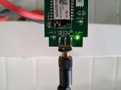 Karta elektroniczna z podłączoną anteną i świecącą diodą LED.