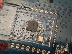 Close-up of a PCB with a black integrated circuit and surrounding SMD components inside a rectangular area