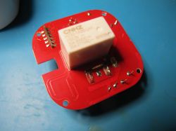 Printed circuit board with CNHZ relay on red laminate.