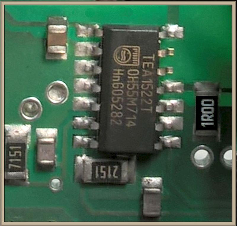 Zbliżenie na zieloną płytkę PCB z układem scalonym i rezystorami SMD z napisami 151, 2151 i 100