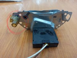 Część mechanizmu lampy bi-xenon Audi A6C5 z pokrętłem regulacyjnym zaznaczonym czerwonym okręgiem.