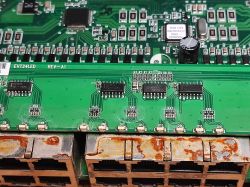 Zbliżenie na zardzewiałe porty Ethernet oraz płytkę drukowaną z układami elektronicznymi w starym switchu sieciowym.