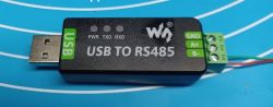 USB to RS485 adapter with three indicator lights and screw terminals on a blue background.