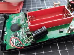 Inside an Open Multimeter View of an open multimeter showing the interior with PCB and replaced capacitor.
