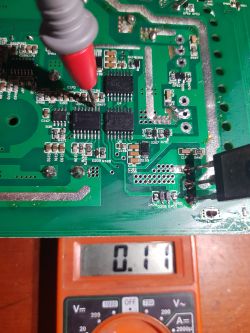 Voltage measurement on a circuit board using a multimeter.