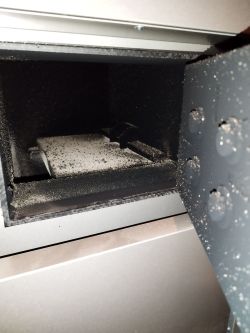 Wnętrze komory spalania pieca z widoczną warstwą sadzy i popiołu