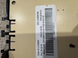 Zbliżenie etykiety z kodem kreskowym i numerami seryjnymi na plastikowym elemencie elektronicznym.