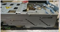 Zdjęcie wnętrza zmieniarki CD z widocznymi częściami mechanicznymi.