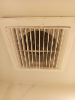 Kratka wentylacyjna sufitowa z siatką, częściowo zabrudzona kurzem
