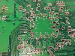 Zbliżenie na zabrudzoną i pokrytą śladami korozji płytkę PCB po powodzi, z elementami SMD.