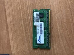 Kość pamięci RAM DDR3 ASint 1GB leży na drewnianej powierzchni.