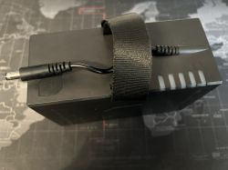 Czarna bateria do przenośnego głośnika z kablem i wskaźnikiem naładowania.