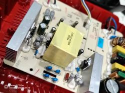 Zbliżenie na płytkę PCB ładowarki Einhell z napuchniętymi kondensatorami elektrolitycznymi