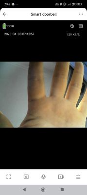 Close-up of a hand with five fingers spread out, seen on a smartphone screen in a doorbell app.
