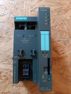 Sterownik Siemens ET200S z widocznymi portami i przyciskiem.