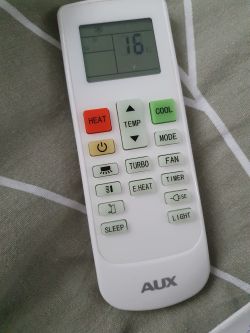 AUX air conditioner remote on a gray background set to 16 degrees Celsius.