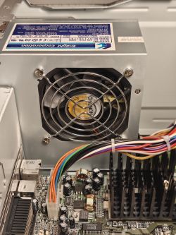 Wnętrze komputera z zasilaczem Enlight Corporation i widocznym wentylatorem oraz płytą główną