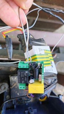 The photo shows a black relay with three terminals mounted on a control board.