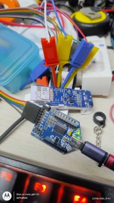 Two blue circuit boards connected with multicolored wires on a desk