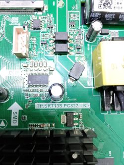 Close-up of a green PCB with SMD chips, capacitors and a transformer; text TP.SK713S.PC822 visible