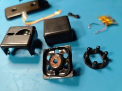 Disassembled SQ11 Mini DV Camera Parts Disassembled parts of the SQ11 Mini DV camera on a blue background.