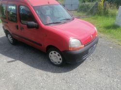 Red Renault Kangoo car parked on a gravel driveway.