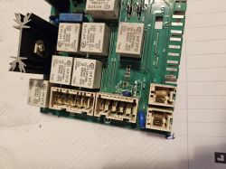Printed circuit board with visible relays and other electronic components.