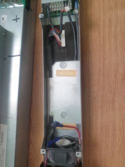 Wnętrze zasilacza z widocznymi elementami elektronicznymi i przewodami.